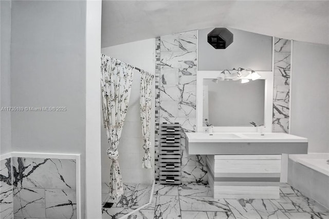 bathroom with vanity, vaulted ceiling, and tile walls