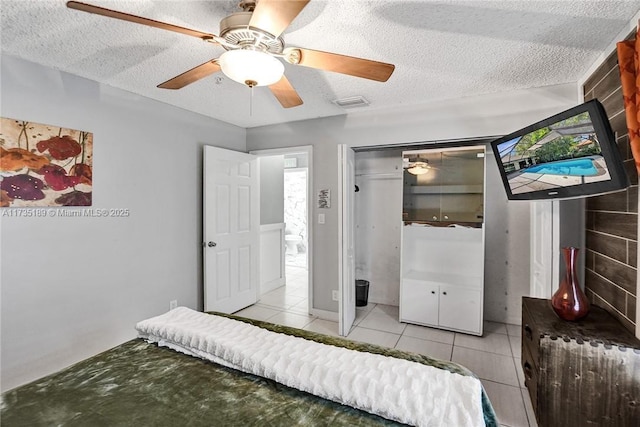 unfurnished bedroom with ceiling fan, a textured ceiling, and light tile patterned floors