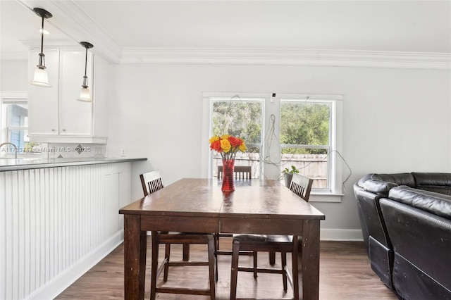 dining space with crown molding and dark hardwood / wood-style floors