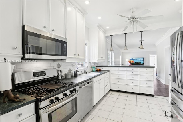 kitchen featuring sink, white cabinetry, ornamental molding, appliances with stainless steel finishes, and pendant lighting