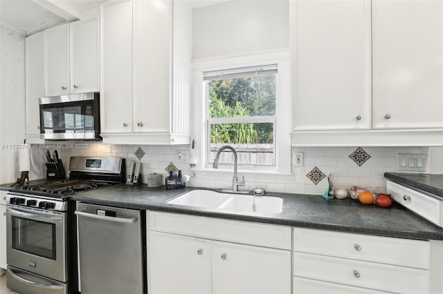 kitchen featuring stainless steel appliances, white cabinetry, sink, and decorative backsplash