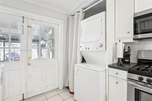 laundry area featuring stacked washer and dryer, crown molding, and light tile patterned floors