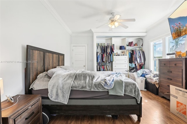 bedroom featuring hardwood / wood-style floors, ornamental molding, a closet, and ceiling fan