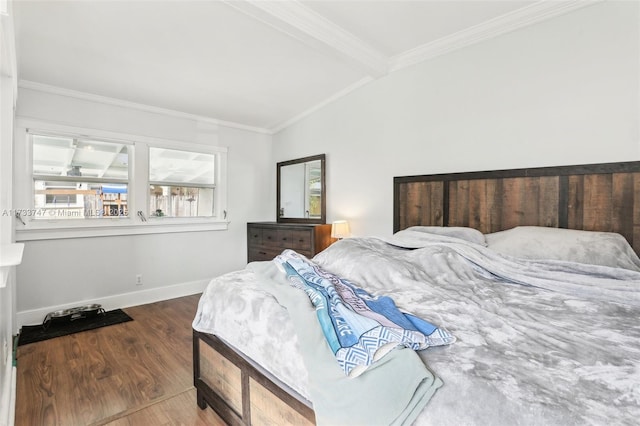 bedroom with hardwood / wood-style flooring, crown molding, and vaulted ceiling with beams