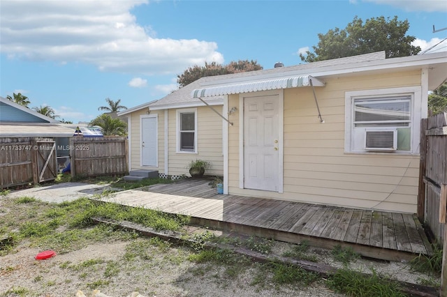 rear view of property with cooling unit and a deck