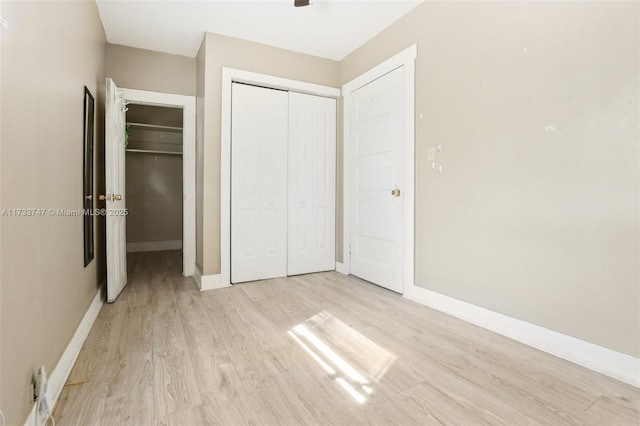 unfurnished bedroom featuring a closet and light hardwood / wood-style flooring