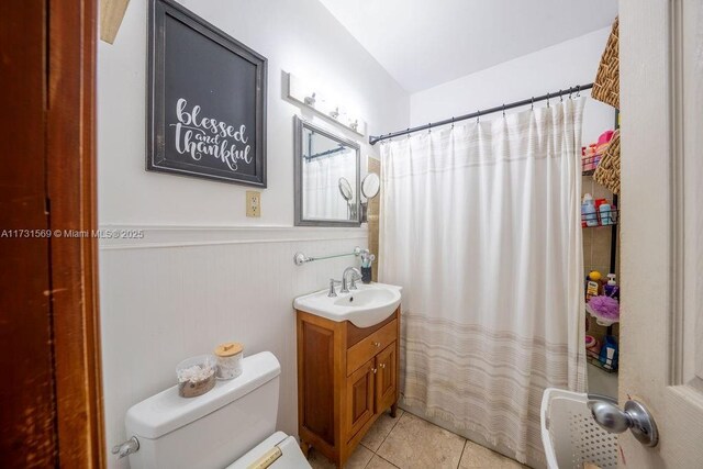 bathroom with tile patterned flooring, vanity, walk in shower, and toilet