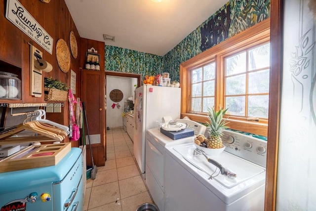 clothes washing area with washer and dryer and light tile patterned floors