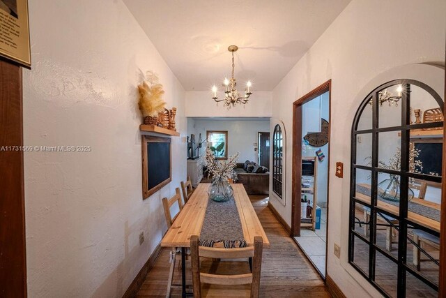 dining room with hardwood / wood-style flooring and a chandelier