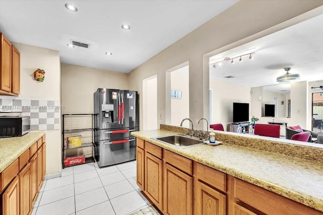 kitchen featuring stainless steel fridge with ice dispenser, decorative backsplash, sink, and light tile patterned flooring