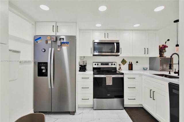 kitchen featuring white cabinetry, appliances with stainless steel finishes, sink, and hanging light fixtures