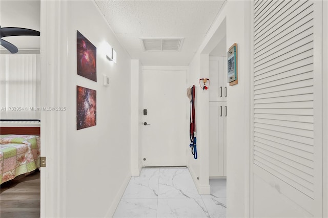 hall featuring a textured ceiling