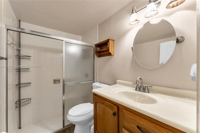 bathroom with vanity, a shower with door, and toilet