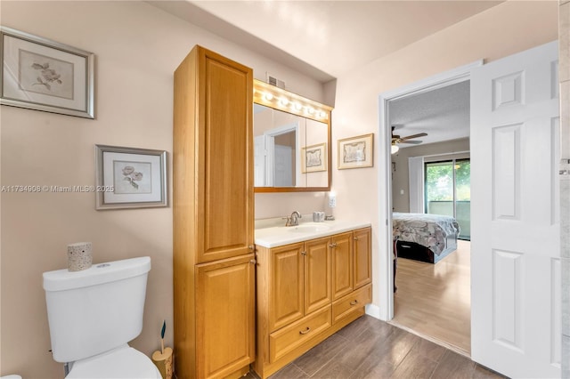 bathroom featuring vanity, ceiling fan, hardwood / wood-style flooring, and toilet