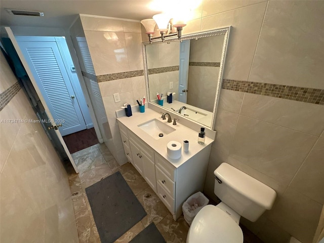 bathroom featuring tile walls, vanity, and toilet