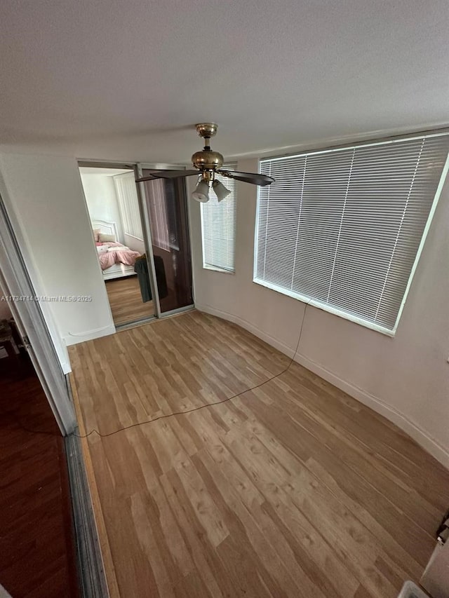 interior space featuring hardwood / wood-style flooring, ceiling fan, a textured ceiling, and a closet