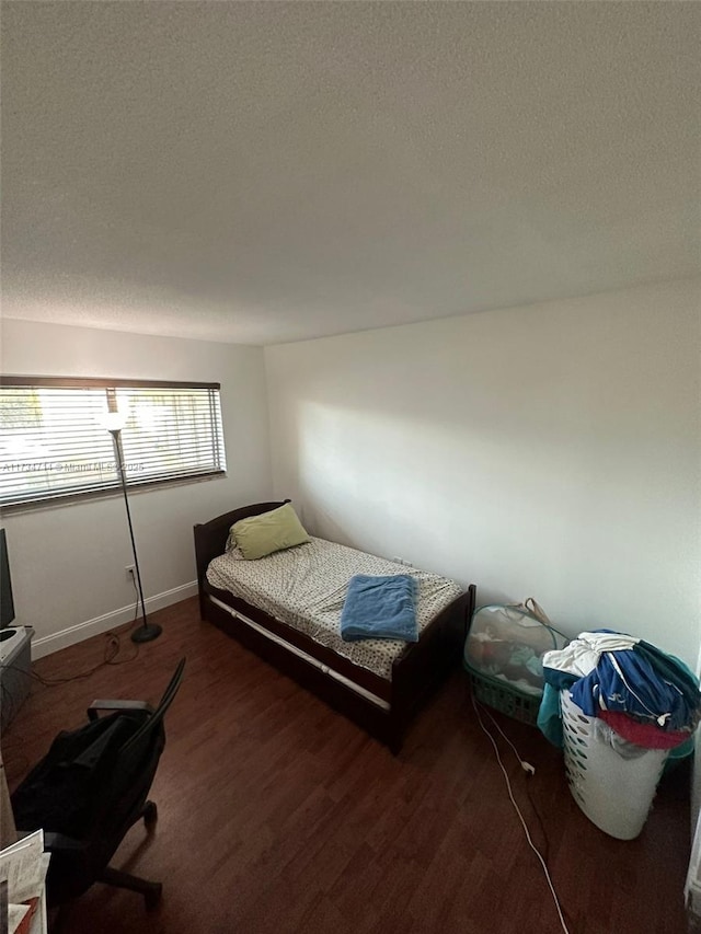 bedroom featuring dark wood-type flooring and a textured ceiling