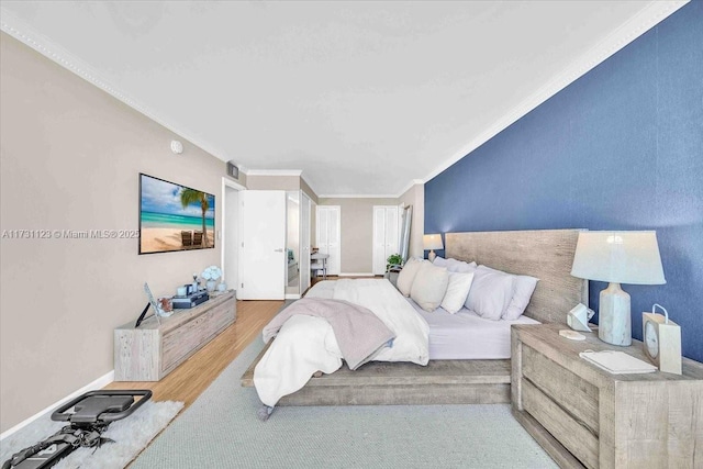 bedroom featuring ornamental molding and light hardwood / wood-style floors