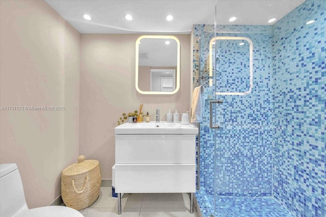 bathroom featuring vanity, toilet, tile patterned flooring, and a shower with door