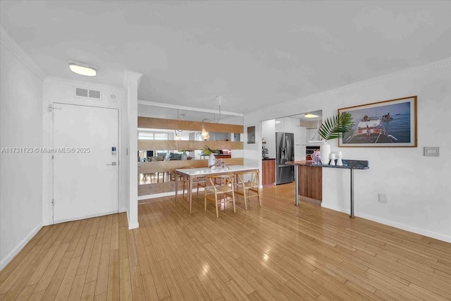 dining room featuring ornamental molding and light hardwood / wood-style flooring