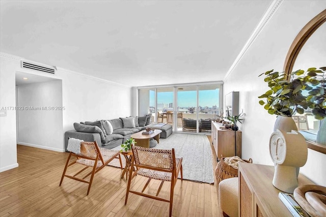 living room featuring ornamental molding, light hardwood / wood-style floors, and a wall of windows