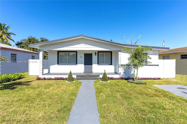 single story home with covered porch and a front yard