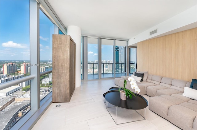 living room with a wall of windows and wood walls