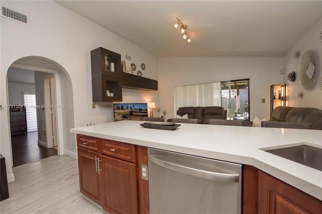 kitchen featuring vaulted ceiling, stainless steel dishwasher, and light hardwood / wood-style floors