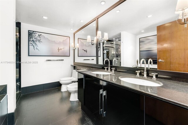 bathroom featuring a bidet, vanity, toilet, and tile patterned floors