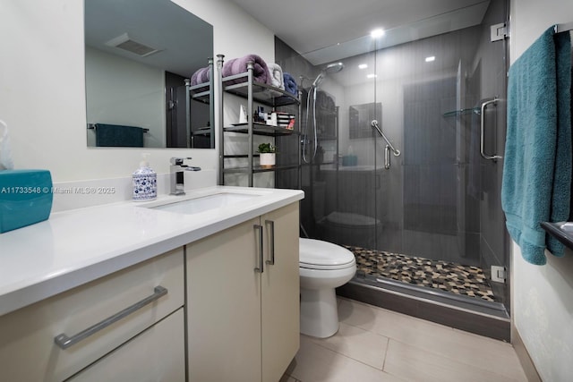 bathroom with vanity, toilet, an enclosed shower, and tile patterned flooring