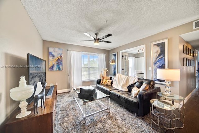 living room featuring a textured ceiling and ceiling fan