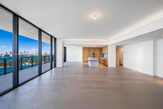 unfurnished living room featuring wood-type flooring and expansive windows