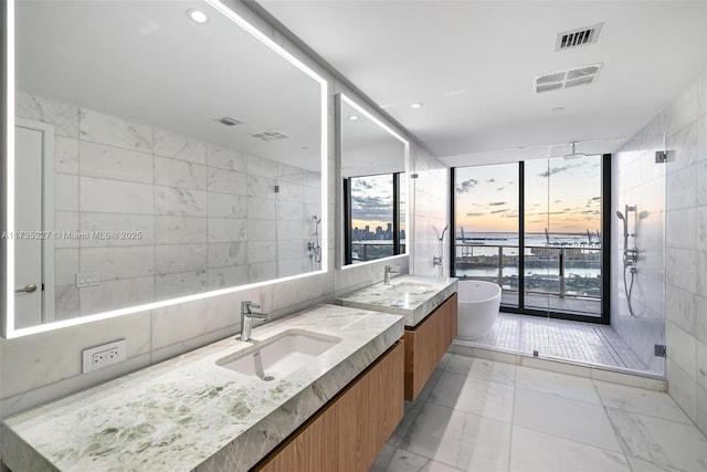 bathroom featuring vanity, a shower with door, and tile walls