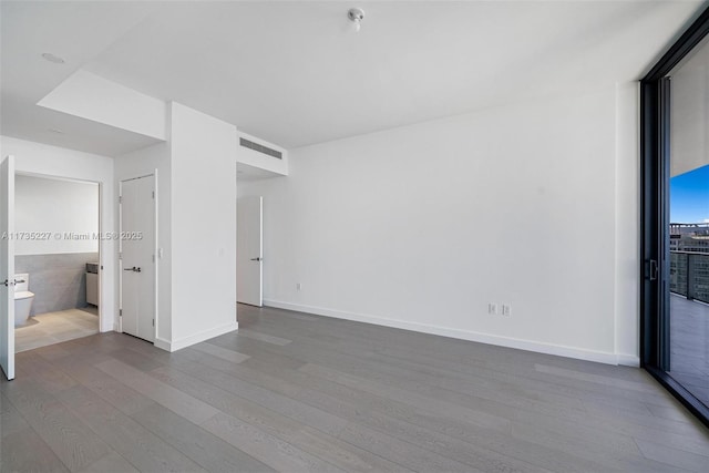 spare room featuring hardwood / wood-style floors and a wall of windows