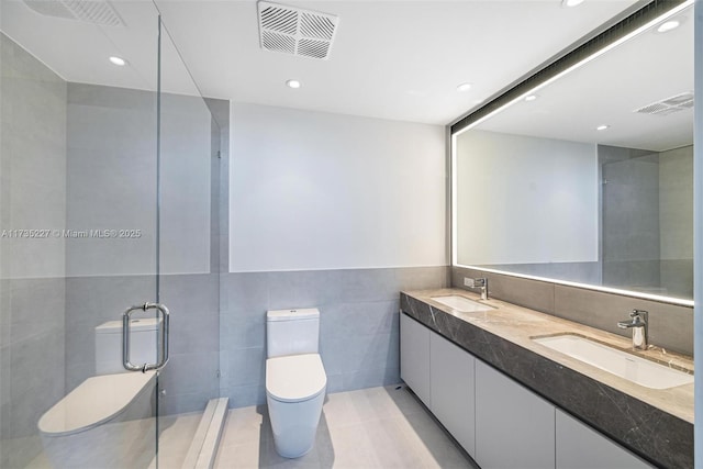 bathroom with tile patterned floors, vanity, toilet, and tile walls