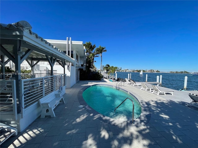 view of pool featuring a water view and a patio area