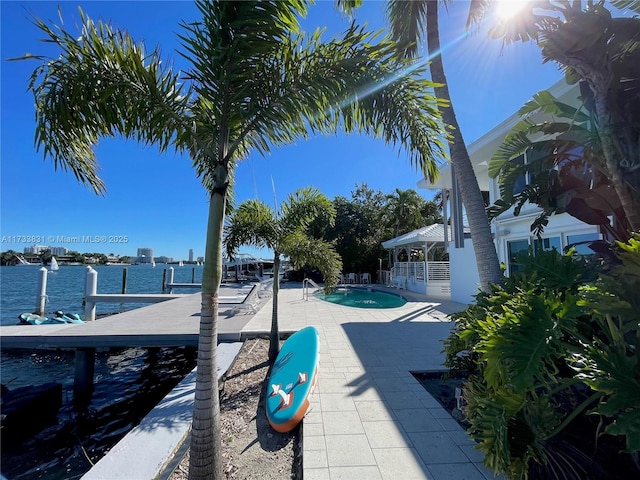 view of swimming pool featuring a patio and a water view