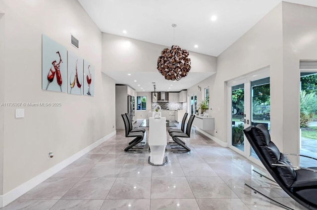 dining space featuring high vaulted ceiling