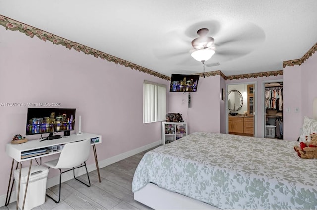 bedroom with a walk in closet, light hardwood / wood-style floors, and a closet