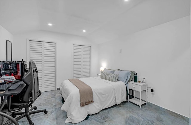 bedroom featuring multiple closets and vaulted ceiling