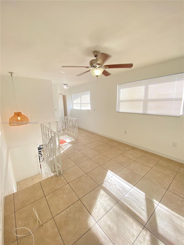 tiled empty room featuring ceiling fan