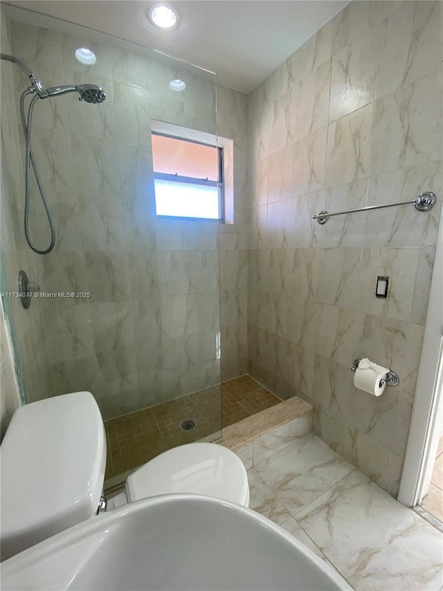 bathroom with tiled shower and toilet