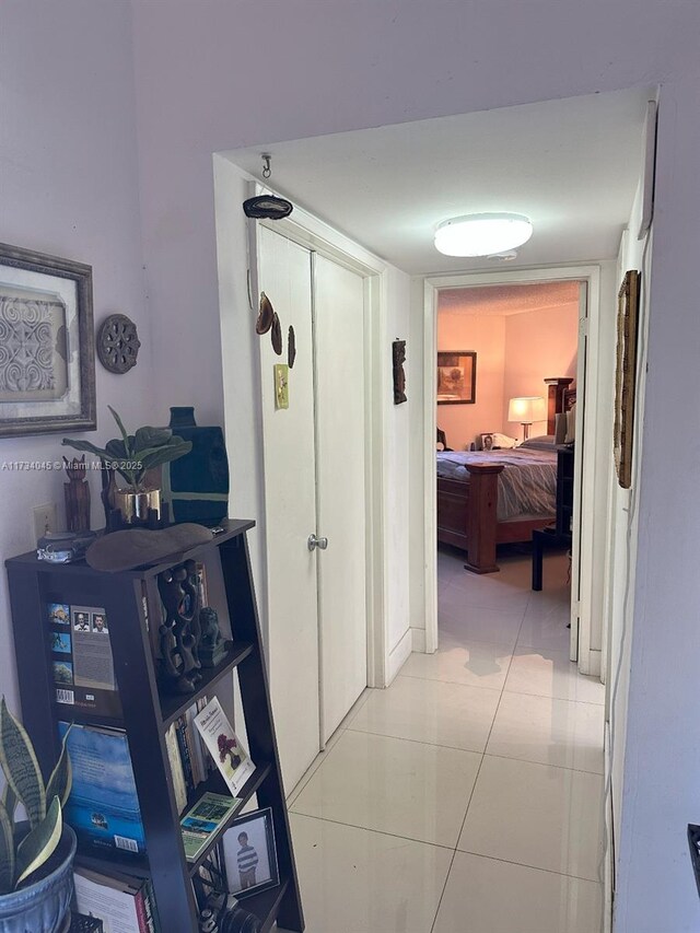 hallway featuring tile patterned floors and a textured ceiling