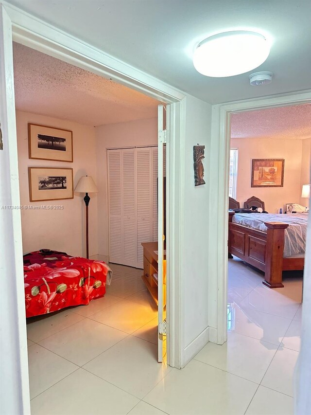 tiled bedroom featuring a textured ceiling and a closet