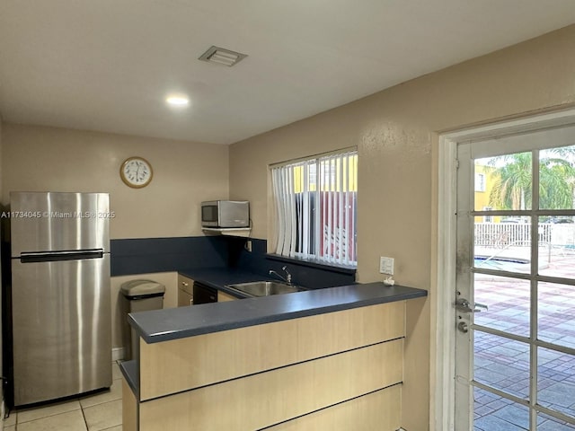 kitchen with sink, a wealth of natural light, stainless steel appliances, and kitchen peninsula