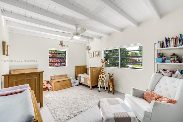 bedroom featuring beamed ceiling, light wood-style floors, and a ceiling fan