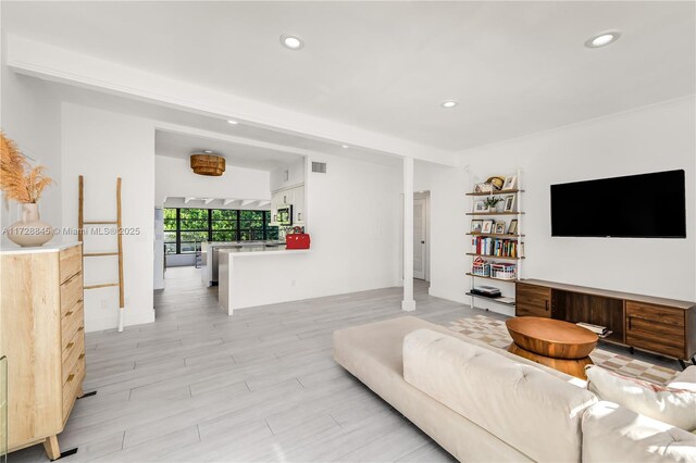 living room with light hardwood / wood-style flooring and beamed ceiling