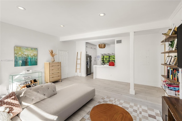 bedroom with light wood-style flooring, recessed lighting, and stainless steel refrigerator with ice dispenser