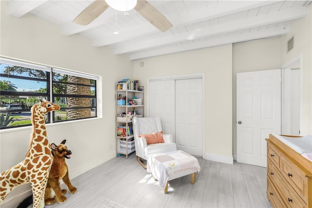 sitting room featuring visible vents, ceiling fan, baseboards, beamed ceiling, and light wood-type flooring