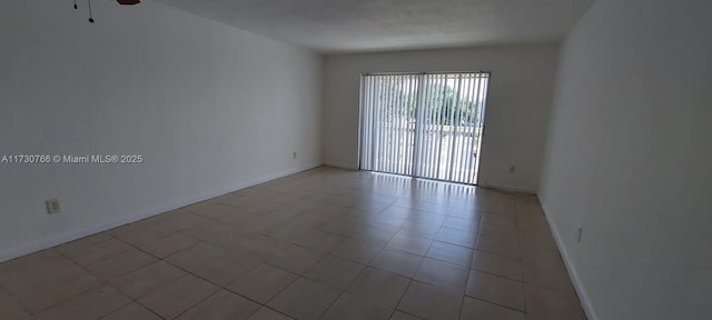 empty room featuring light tile patterned floors and ceiling fan